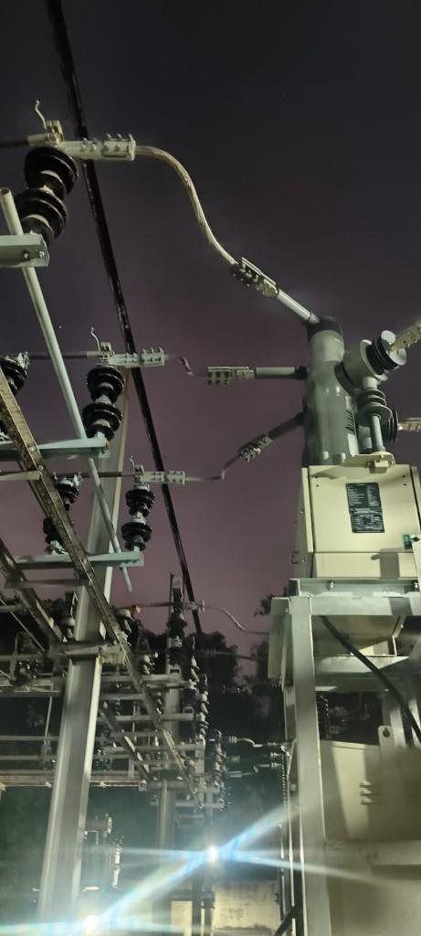Substation conductors, insulators, and switching equipment photographed during night work